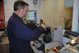 Lock & Key Employee Cutting A Key